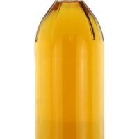 A bottle of filtered Apple Cider Vinegar isolated on white