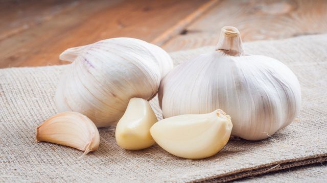 Organic garlic whole and cloves on the wooden background