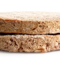 Two frozen hamburger patties isolated on white.