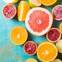 Citrus fruits on turquoise abstract background. Оrange, lemon, grapefruit, mandarin, lime. Mixed festive colorful tropical and citrus fruit sliced. Healthy eating photo concept. Copyspace