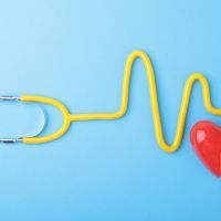 Red heart and a stethoscope on blue background