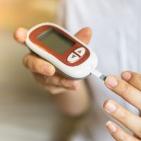 Close up of woman hands using Glucose meter on finger to check blood sugar level. Use as Medicine, diabetes, glycemia, health care and people concept.