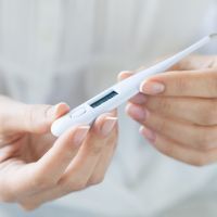 Woman looking at thermometer