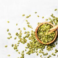 Fresh pumpkin seeds, gray food background, top view